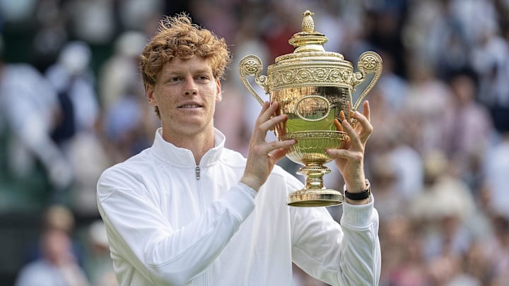 Jul 13, 2025; Wimbledon, United Kingdom; Jannik Sinner of Italy poses with the trophy after winning the men’s singles final match against Carlos Alcaraz of Spain on day 14 at All England Lawn Tennis and Croquet Club.