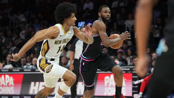 Jan 4, 2026; Miami, Florida, USA;  Miami Heat forward Andrew Wiggins (22) brings the ball up the court as New Orleans Pelicans guard Micah Peavy (14) defends during the first half at Kaseya Center. Mandatory Credit: Jim Rassol-Imagn Images