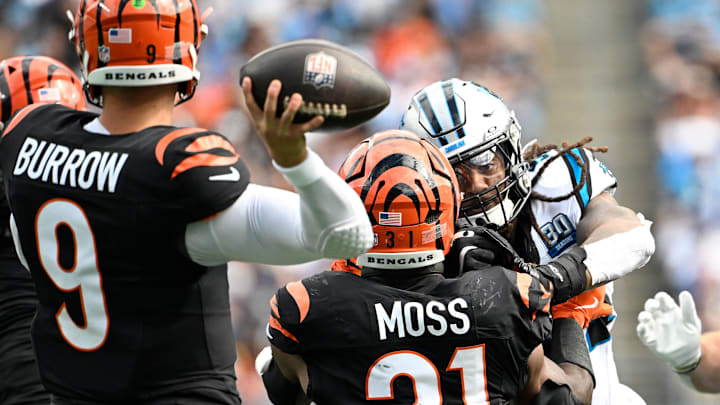 Sep 29, 2024; Charlotte, North Carolina, USA;  Cincinnati Bengals quarterback Joe Burrow (9) prepares to throw the ball as running back Zack Moss (31) blocks and Carolina Panthers defensive end A'Shawn Robinson (94) pressures in the third quarter at Bank of America Stadium. Mandatory Credit: Bob Donnan-Imagn Images