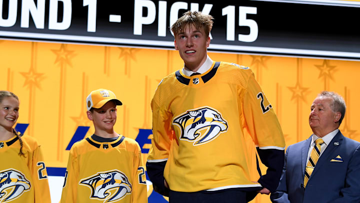 Jun 28, 2023; Nashville, Tennessee, USA; Nashville Predators draft pick Matthew Wood puts on his sweater after being selected with the fifteenth pick in round one of the 2023 NHL Draft at Bridgestone Arena. Mandatory Credit: Christopher Hanewinckel-Imagn Images