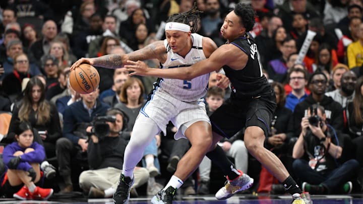 Orlando Magic forward Paolo Banchero (5) dribbles against Toronto Raptors forward Scottie Barnes (4) in the second half at Scotiabank Arena.
