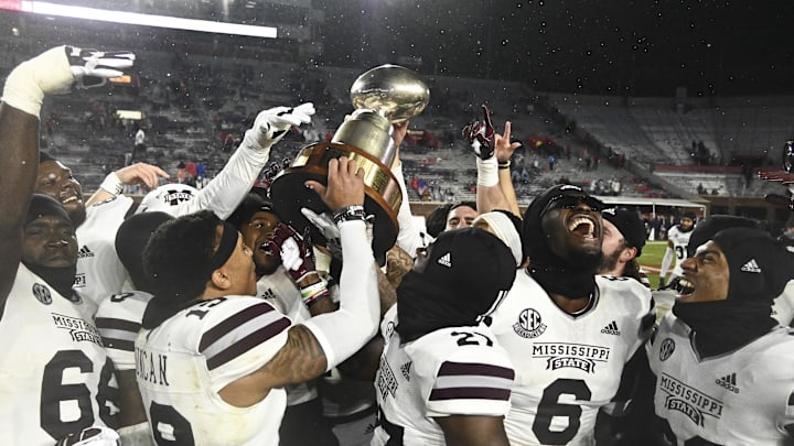 Nov 24, 2022; Oxford, Mississippi, USA; Mississippi State Bulldogs players celebrates with the Egg Bowl trophy after the game against the Ole Miss Rebels at Vaught-Hemingway Stadium. Mandatory Credit: Matt Bush-Imagn Images