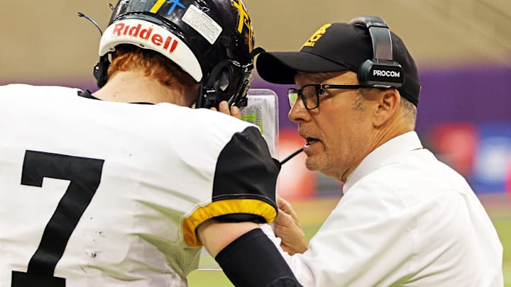 Bishop Garrigan (Algona) sophomore quarterback Tate Foertsch (7) listens to Bishop Garrigan (Algona) Head Coach Marty Wadle as the Bishop Garrigan (Algona) Golden Bears compete against the Bedford Bulldogs for the Eight-Player championship on Thursday, November 16, 2023 at the UNI-Dome in Cedar Falls.
