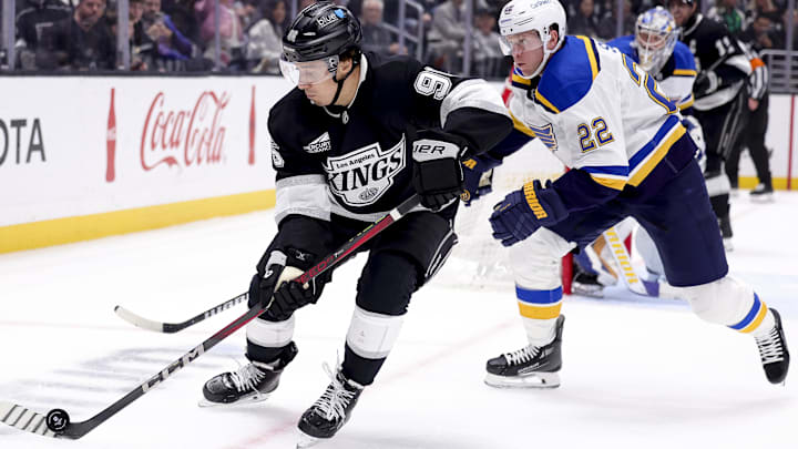 Mar 8, 2025; Los Angeles, California, USA; Los Angeles Kings left wing Andrei Kuzmenko (96) moves the puck ahead of St. Louis Blues defenseman Ryan Suter (22) during the second period at Crypto.com Arena. Mandatory Credit: Ryan Sun-Imagn Images