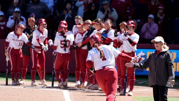 Oklahoma coach Patty Gasso high-fives catcher Kendall Wells after she hit a home run at Love's Field.