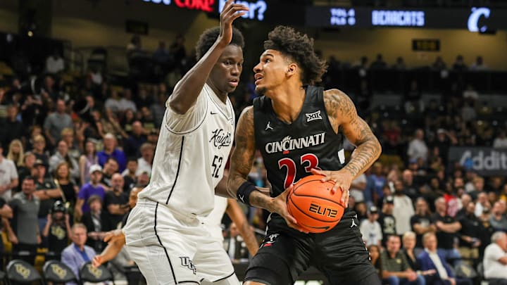 Feb 5, 2025; Orlando, Florida, USA; Cincinnati Bearcats forward Dillon Mitchell (23) goes to the basket against UCF Knights center Moustapha Thiam (52) during the first half at Addition Financial Arena. Mandatory Credit: Mike Watters-Imagn Images Feb 5, 2025; Orlando, Florida, USA; Cincinnati Bearcats forward Dillon Mitchell (23) goes to the basket against UCF Knights center Moustapha Thiam (52) during the first half at Addition Financial Arena. Mandatory Credit: Mike Watters-Imagn Images