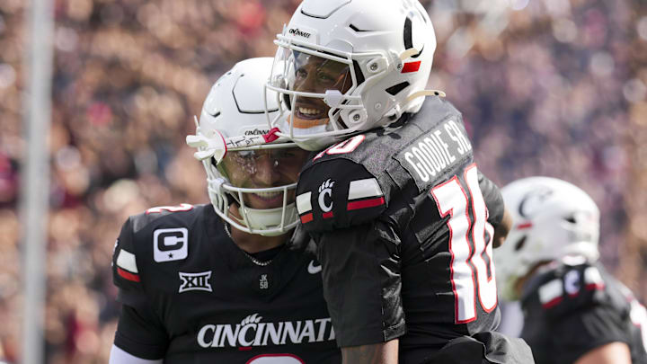 Sep 13, 2025; Cincinnati, Ohio, USA;  Cincinnati Bearcats wide receiver Caleb Goodie (10) celebrates with quarterback Brendan Sorsby (2) after scoring a touchdown against the Northwestern State Demons in the first half at Nippert Stadium. Mandatory Credit: Aaron Doster-Imagn Images