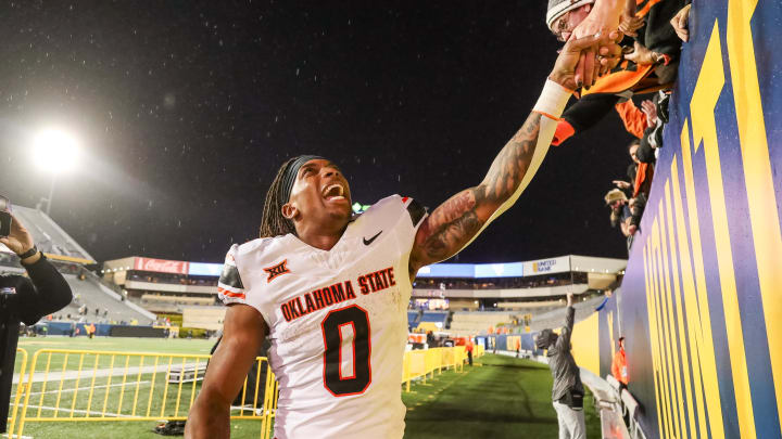 Oct 21, 2023; Morgantown, West Virginia, USA; Oklahoma State Cowboys running back Ollie Gordon II (0) celebrates with fans after defeating the West Virginia Mountaineers at Mountaineer Field at Milan Puskar Stadium. Mandatory Credit: Ben Queen-USA TODAY Sports