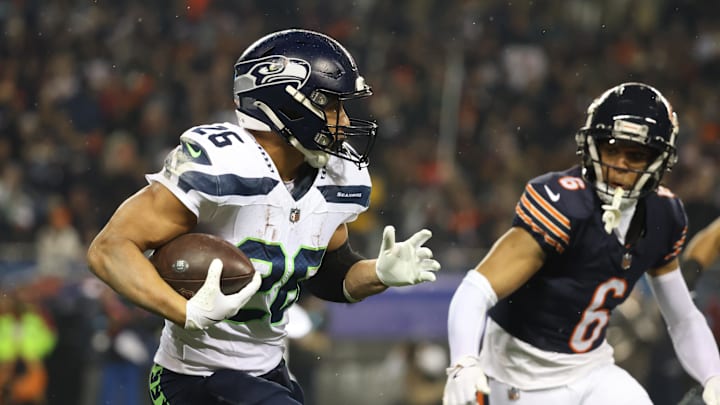 Dec 26, 2024; Chicago, Illinois, USA; Seattle Seahawks running back Zach Charbonnet (26) runs for a gain as Chicago Bears cornerback Kyler Gordon (6) defends during the first quarter at Soldier Field. Mandatory Credit: Talia Sprague-Imagn Images
