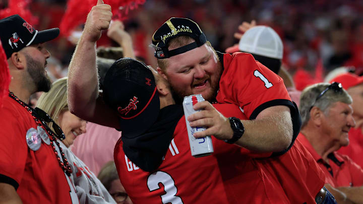 Georgia Bulldogs fans hug it out on a critical fourth down during the fourth quarter of an NCAA football game, Saturday, Nov. 1, 2025, at EverBank Stadium in Jacksonville, Fla. Georgia held off Florida 24-20. [Corey Perrine/Florida Times-Union]