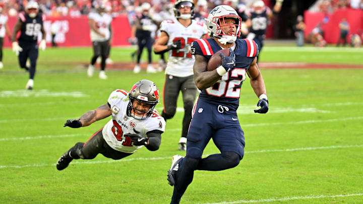 Nov 9, 2025; Tampa, Florida, USA; New England Patriots running back Treveyon Henderson (32) runs for a touchdown past Tampa Bay Buccaneers cornerback Josh Hayes (32) during the third quarter at Raymond James Stadium. 
