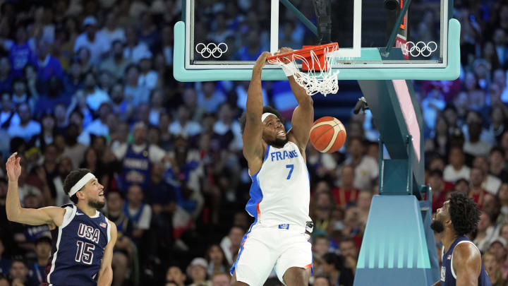 Aug 10, 2024; Paris, France; France power forward Guerschon Yabusele (7) dunks against United States guard Devin Booker (15) and centre Joel Embiid (11) in the first quarter in the men's basketball gold medal game during the Paris 2024 Olympic Summer Games at Accor Arena. Mandatory Credit: Kyle Terada-USA TODAY Sports