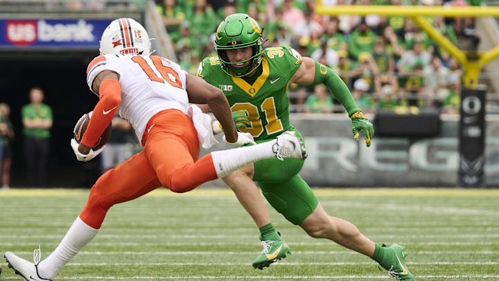 Sep 6, 2025; Eugene, Oregon, USA; Oregon Ducks defensive back Dillon Thieneman (31) runs after Oklahoma State Cowboys wide receiver Christian Fitzpatrick (16) during the first half at Autzen Stadium. Mandatory Credit: Troy Wayrynen-Imagn Images