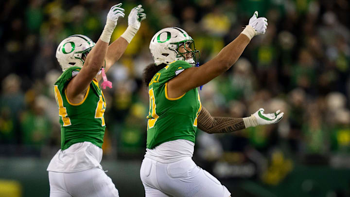 Oregon's Matayo Uiagalelei, right, and Teitum Tuioti take the field as the Oregon Ducks host the Minnesota Golden Gophers.
