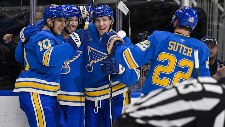 Nov 2, 2024; St. Louis, Missouri, USA;  St. Louis Blues center Jordan Kyrou (25) celebrates with center Brayden Schenn (10) center Dylan Holloway (81) and defenseman Ryan Suter (22) after scoring against the Toronto Maple Leafs during the second period at Enterprise Center. Mandatory Credit: Jeff Curry-Imagn Images