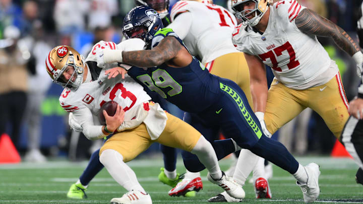 Jan 17, 2026; Seattle, WA, USA; San Francisco 49ers quarterback Brock Purdy (13) is sacked by Seattle Seahawks defensive end Leonard Williams (99) during the second half in an NFC Divisional Round game at Lumen Field. Mandatory Credit: Steven Bisig-Imagn Images