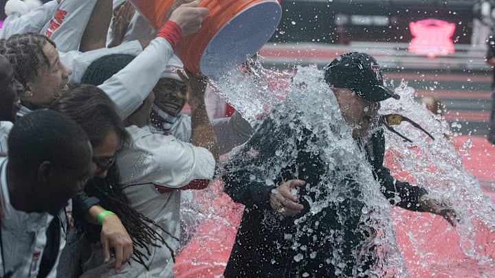 Texas Tech crossing country, track and field coach Wes Kittley has a water jug poured on him after