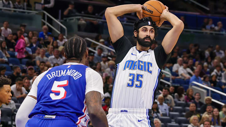 Oct 18, 2024; Orlando, Florida, USA; Orlando Magic center Goga Bitadze (35) passes the ball in front of Philadelphia 76ers center Andre Drummond (5) during the second half at Kia Center. Mandatory Credit: Mike Watters-Imagn Images