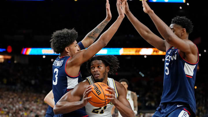 Apr 6, 2026; Indianapolis, IN, USA; Michigan Wolverines forward Morez Johnson Jr. (21) drives to the basket against UConn Huskies forward Jaylin Stewart (3) and forward Tarris Reed Jr. (5) during the second half in the national championship of the Final Four of the men's 2026 NCAA Tournament between the  and the Michigan Wolverines at Lucas Oil Stadium. Mandatory Credit: Bob Donnan-Imagn Images