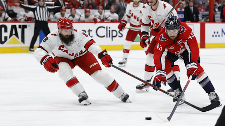May 15, 2025; Washington, District of Columbia, USA; Washington Capitals right wing Tom Wilson (43) reaches for the puck as Carolina Hurricanes defenseman Brent Burns (8) defends in the third period in game five of the second round of the 2025 Stanley Cup Playoffs at Capital One Arena. Mandatory Credit: Geoff Burke-Imagn Images