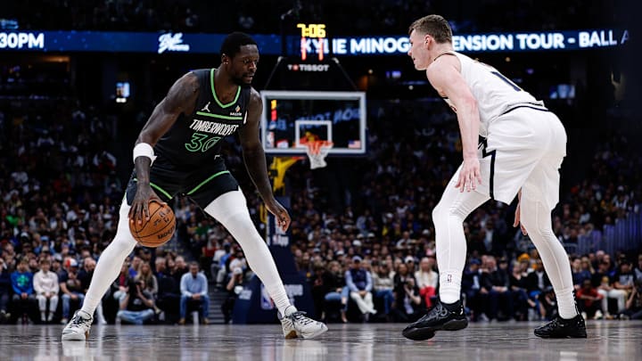 Apr 1, 2025; Denver, Colorado, USA; Minnesota Timberwolves forward Julius Randle (30) controls the ball as Denver Nuggets guard Christian Braun (0) guards in the second quarter at Ball Arena. Mandatory Credit: Isaiah J. Downing-Imagn Images