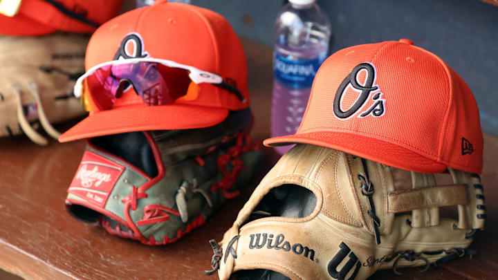 Mar 11, 2024; Tampa, Florida, USA;  A detailed view of Baltimore Orioles baseball hats and gloves in the dugout during the first inning against the New York Yankees at George M. Steinbrenner Field.