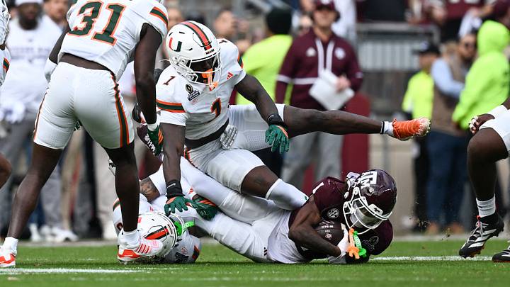 Dec 20, 2025; College Station, TX, USA; Texas A&M Aggies wide receiver Mario Craver (1) carries the ball against Miami Hurricanes linebacker Mohamed Toure (1) during the first round of the CFP National Playoff at Kyle Field. Mandatory Credit: Maria Lysaker-Imagn Images