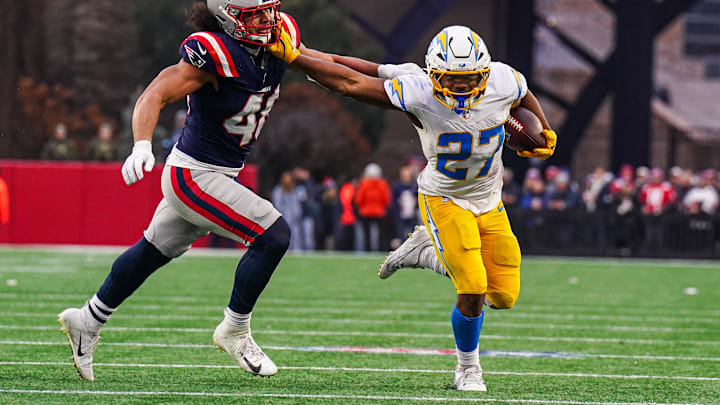 Dec 28, 2024; Foxborough, Massachusetts, USA; Los Angeles Chargers running back J.K. Dobbins (27) runs the ball against New England Patriots linebacker Jahlani Tavai (48) in the second half at Gillette Stadium. Mandatory Credit: David Butler II-Imagn Images