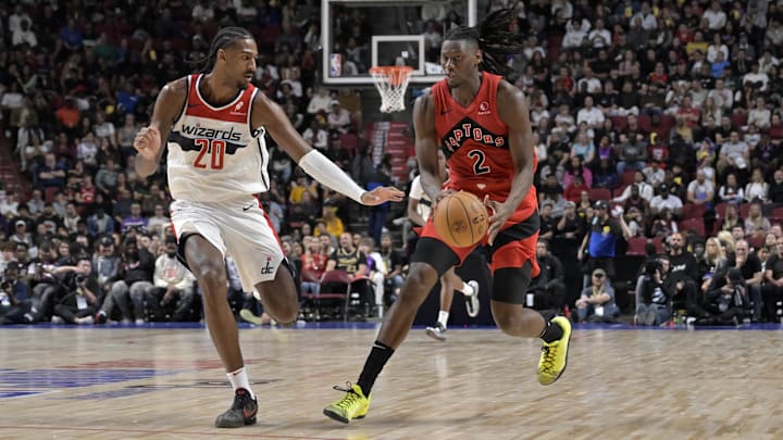 Oct 6, 2024; Montreal, Quebec, CAN; Toronto Raptors forward Jonathan Mogbo (2) dribbles and Washington Wizards power forward Alex Sarr (20) defends during the third quarter at the Bell Centre. Mandatory Credit: Eric Bolte-Imagn Images