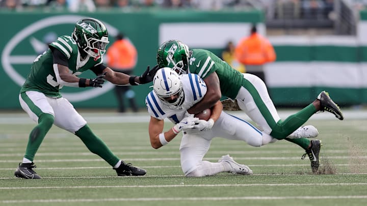 Nov 17, 2024; East Rutherford, New Jersey, USA; Indianapolis Colts wide receiver Alec Pierce (14) is tackled by New York Jets cornerback D.J. Reed (4) and safety Jalen Mills (35) during the third quarter at MetLife Stadium. 
