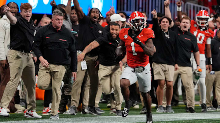 The Georgia sideline goes wild while Georgia running back Trevor Etienne (1) breaks away for a big gain during the second half of the SEC championship game against Texas in Atlanta, on Saturday, Dec. 7, 2024.