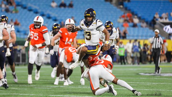 Sep 19, 2026; Charlotte, North Carolina, USA; West Virginia Mountaineers quarterback Michael Hawkins Jr. (3) runs the ball and jumps over a defender during the first quarter against the Virginia Cavaliers at Bank of America Stadium. Sep 19, 2026; Charlotte, North Carolina, USA; West Virginia Mountaineers quarterback Michael Hawkins Jr. (3) runs the ball and jumps over a defender during the first quarter against the Virginia Cavaliers at Bank of America Stadium.
