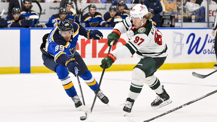 Nov 19, 2024; St. Louis, Missouri, USA;  Minnesota Wild left wing Kirill Kaprizov (97) shoots as St. Louis Blues left wing Pavel Buchnevich (89) defends during the third period at Enterprise Center. Mandatory Credit: Jeff Curry-Imagn Images