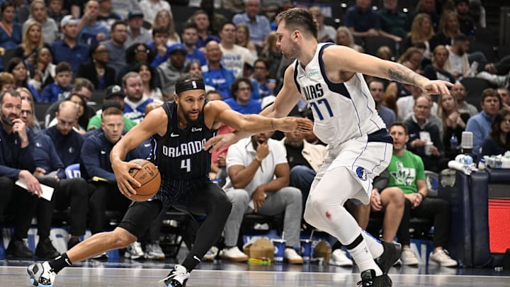 Orlando Magic guard Jalen Suggs (4) looks to move the ball past Dallas Mavericks guard Luka Doncic (77) during the second half at the American Airlines Center. Orlando Magic guard Jalen Suggs (4) looks to move the ball past Dallas Mavericks guard Luka Doncic (77) during the second half at the American Airlines Center.
