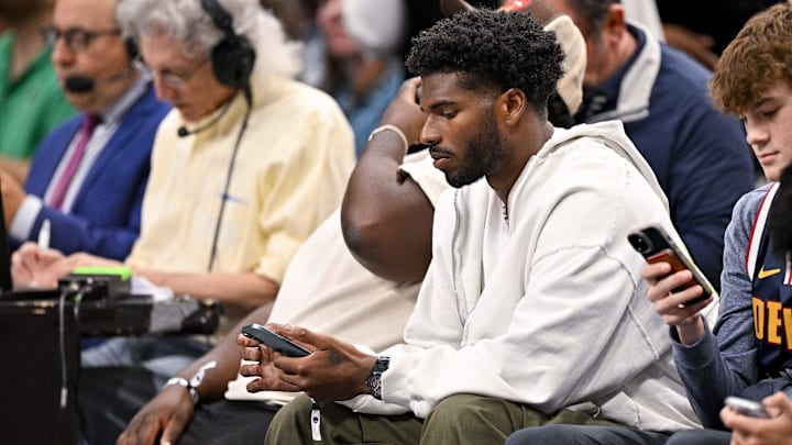 Jan 14, 2025; Dallas, Texas, USA; Colorado Buffaloes quarterback Shedeur Sanders checks his phone during the game between the Dallas Mavericks and the Denver Nuggets in the second quarter at the American Airlines Center. 