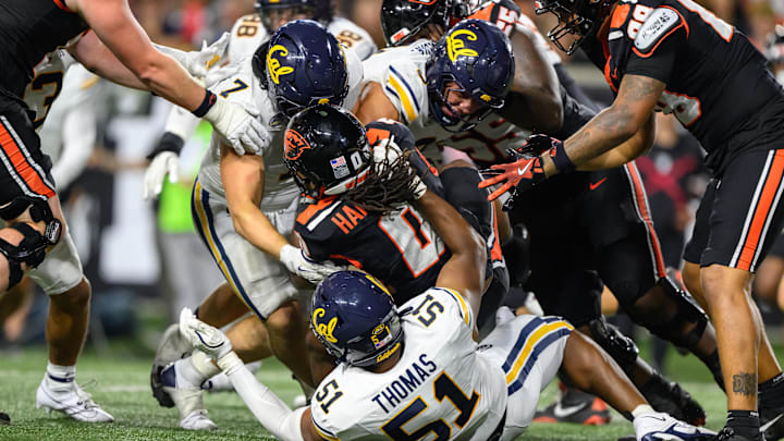 Cal's defense, including Harrison Taggart (7) and Curlee Thomas IV (51), stops Oregon State running back Anthony Hankerson