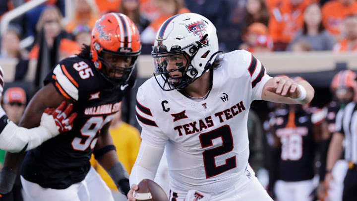 Texas Tech's Behren Morton (2) runs the ball away from Oklahoma State's Jaleel Johnson during an NCAA football game on Saturday, Nov. 23, 2024, in Stillwater, Okla.