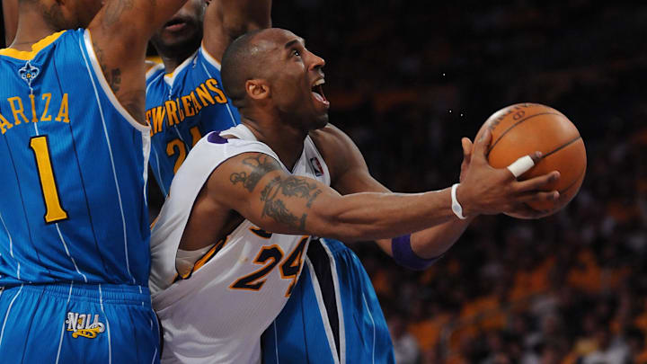 Mar 17, 2011; Los Angeles, CA, USA;  Los Angeles Lakers guard Kobe Bryant (24) goes through the lane and is fouled by New Orleans Hornets power forward Carl Landry (24) as New Orleans Hornets small forward Trevor Ariza (1) also defends during the second half of game one of the first round of the 2011 NBA playoffs at the at Staples Center. Hornets won 109-100.   Mandatory Credit: Jayne Kamin-Oncea-Imagn Images