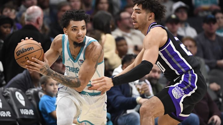Jan 10, 2024; Charlotte, North Carolina, USA; Charlotte Hornets guard James Bouknight (2) looks to pass as he is defended by Sacramento Kings guard forward Colby Jones (20) during the first half at the Spectrum Center. Mandatory Credit: Sam Sharpe-Imagn Images