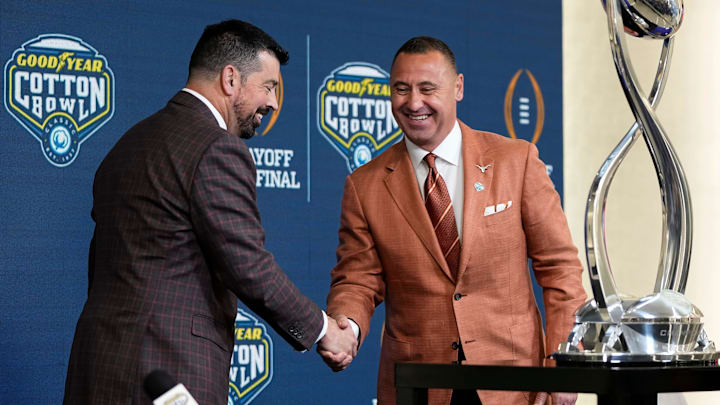 Ohio State Buckeyes head coach Ryan Day and Texas Longhorns head coach Steve Sarkisian shake hands after a press conference.