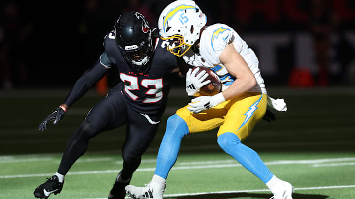 Jan 11, 2025; Houston, Texas, USA; Los Angeles Chargers wide receiver Ladd McConkey (15) carries the ball defended by Houston Texans safety Eric Murray (23) during the first quarter in an AFC wild card game at NRG Stadium. Mandatory Credit: Troy Taormina-Imagn Images