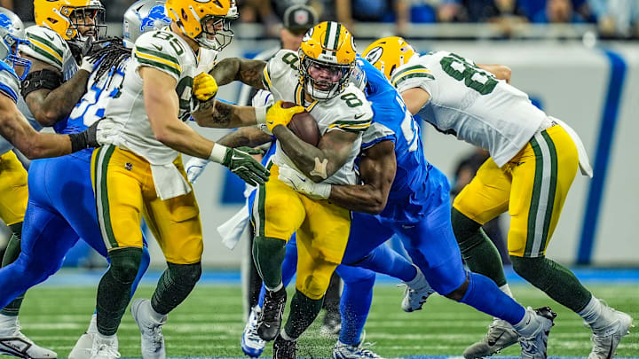 Green Bay Packers running back Josh Jacobs breaks through the Detroit Lions defensive line before being tackled during the Thursday Night Football game at Ford Field in Detroit on Thursday, Dec. 5, 2024. Jacobs scored three rushing touchdowns in the Lions' 34-31 win.