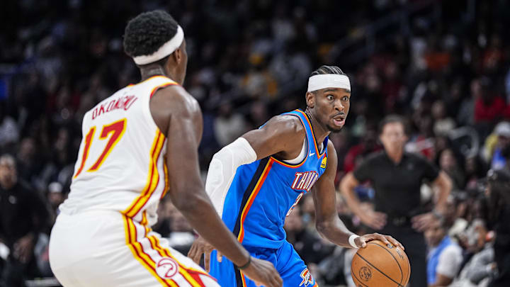 Oct 25, 2025; Atlanta, Georgia, USA; Oklahoma City Thunder guard Shai Gilgeous-Alexander (2) dribbles against Atlanta Hawks forward Onyeka Okongwu (17) during the second half at State Farm Arena. Mandatory Credit: Dale Zanine-Imagn Images