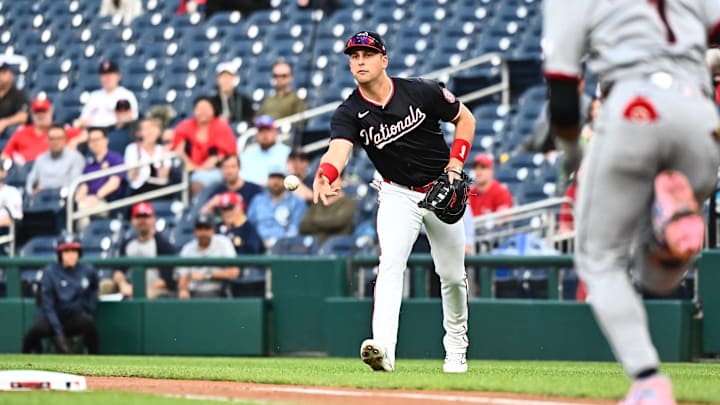 Washington, District of Columbia, USA; Washington Nationals first baseman Nathaniel Lowe (33) tossed the ball to starting pitcher Brad Lord (not pictured) during the first inning against the Cleveland Guardians at Nationals Park.