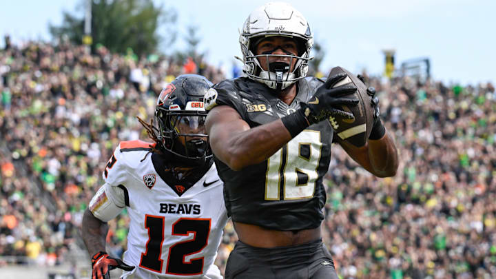 Sep 20, 2025; Eugene, Oregon, USA; Oregon Ducks tight end Kenyon Sadiq (18) makes a reception Oregon State Beavers defensive back Tyrice Ivy Jr. (12) of the game at Autzen Stadium. Sadiq scored a touchdown on the play. 