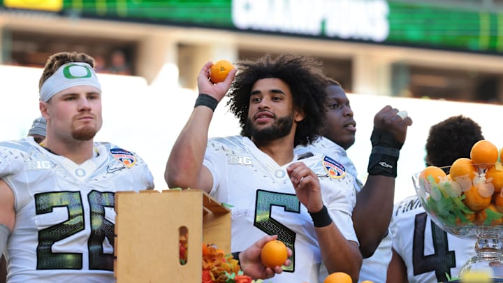 Jan 1, 2026; Miami Gardens, FL, USA; Oregon Ducks linebacker Devon Jackson (26) and quarterback Dante Moore (5) celebrate following the 2025 Orange Bowl and quarterfinal game of the College Football Playoff against the Texas Tech Red Raiders at Hard Rock Stadium. Mandatory Credit: Sam Navarro-Imagn Images