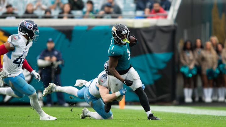 Dec 29, 2024; Jacksonville, Florida, USA; Tennessee Titans linebacker Luke Gifford (57) tackles Jacksonville Jaguars running back Travis Etienne Jr (1) in the fourth quarter at EverBank Stadium. Mandatory Credit: Jeremy Reper-Imagn Images