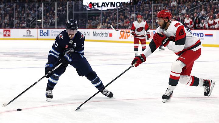 Nov 21, 2025; Winnipeg, Manitoba, CAN; Winnipeg Jets center Mark Scheifele (55) is stick-checked by Carolina Hurricanes defenseman K'Andre Miller (19) in the second period at Canada Life Centre. Mandatory Credit: James Carey Lauder-Imagn Images