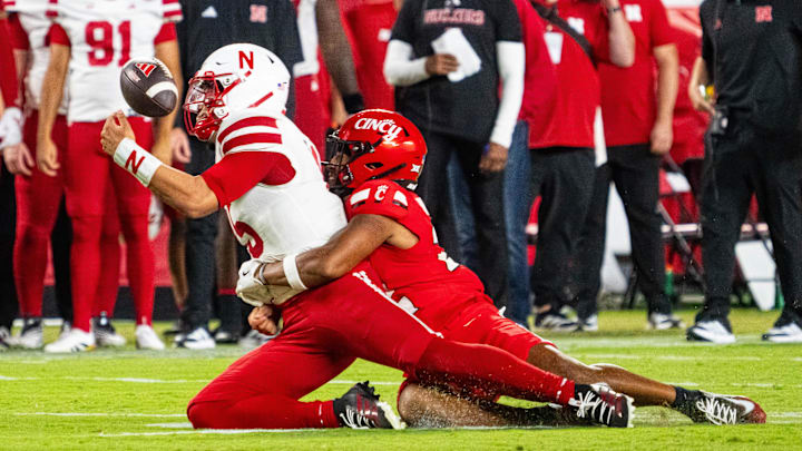 Aug 28, 2025; Kansas City, Missouri, USA; Nebraska Cornhuskers quarterback Dylan Raiola (15) fumbles against Cincinnati Bearcats linebacker Jonathan Thompson (22) during the second quarter at GEHA Field at Arrowhead Stadium. Mandatory Credit: Dylan Widger-Imagn Images