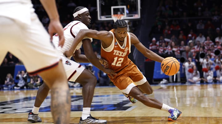 Texas Longhorns guard Tramon Mark dribbles while defended by NC State Wolfpack center Scottie Ebube in the second half during a First Four game of the men's 2026 NCAA Tournament at University of Dayton Arena.